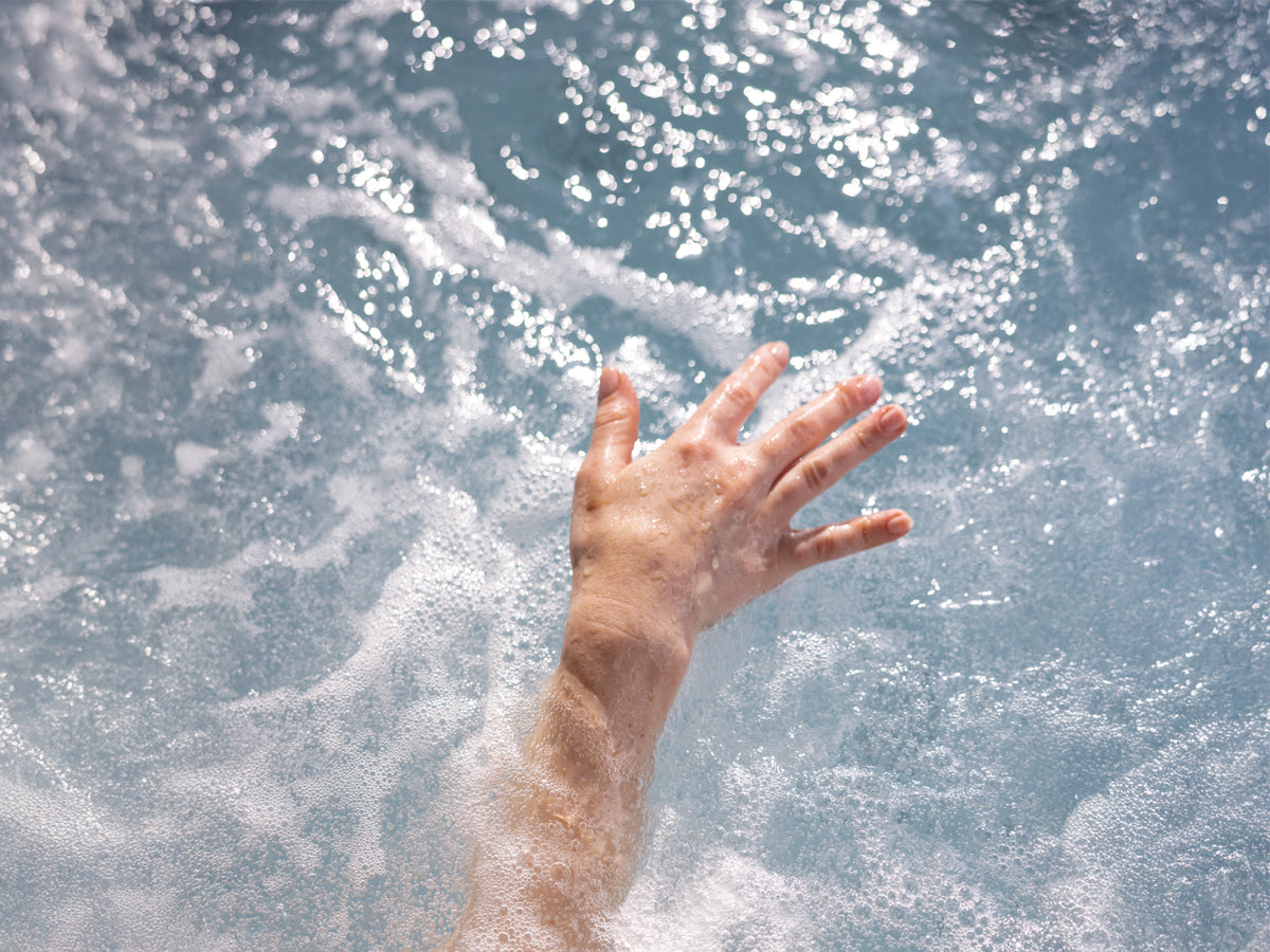 Hand Touching Bubbling Spa Water Blog Image - The Great Escape